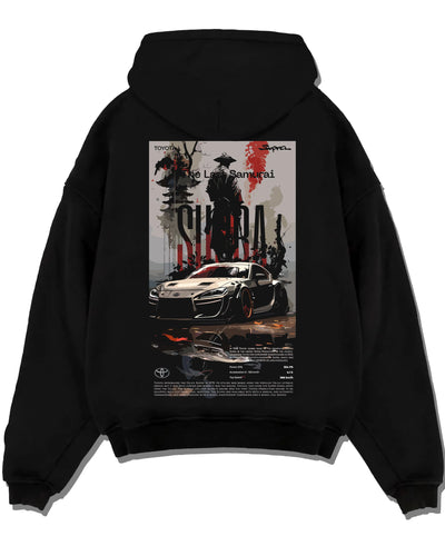 Black pullover hoodie laid flat on a white background, featuring Toyota Supra racing jdm japanese tuning street enthusiast graphic.