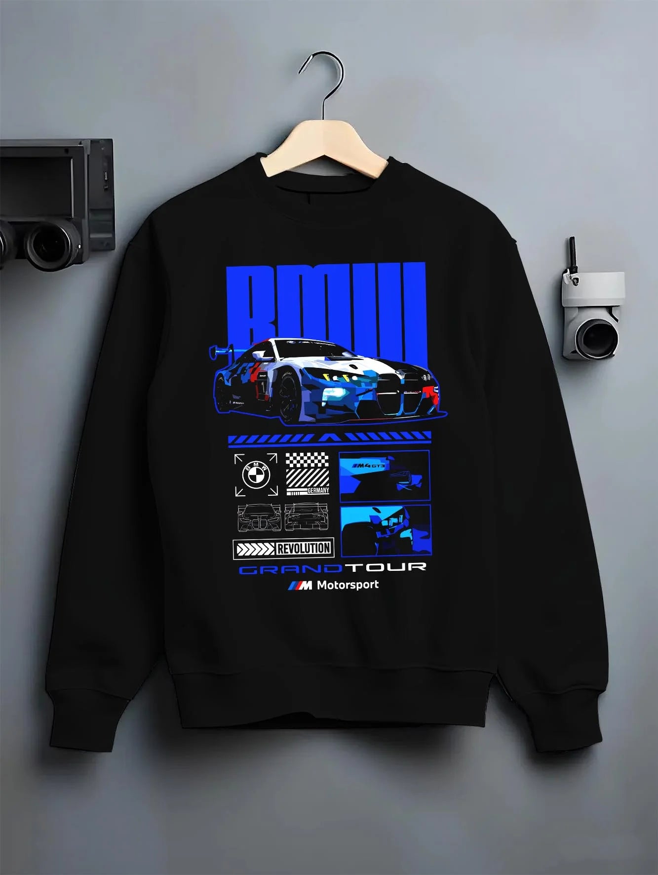 Black crewneck sweatshirt on a hanger against a grey wall, featuring BMW M4 gt3 rs turbo racing motorsport german street graphic.