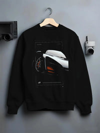 Black crewneck sweatshirt on a hanger against a grey wall, featuring McLaren F1 rs racing street retro speed enthusiast graphic.