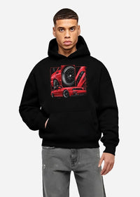 Black hoodie worn by a male model, front view, featuring street retro racing performance motorsport automotive enthusiast graphic.