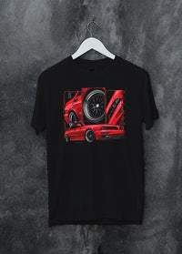Black crewneck T-shirt on a hanger against a grey wall, featuring street retro racing performance motorsport automotive graphic.