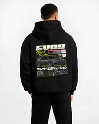 Black hoodie worn by a male model, back view, featuring street retro racing performance motorsport automotive enthusiast graphic.
