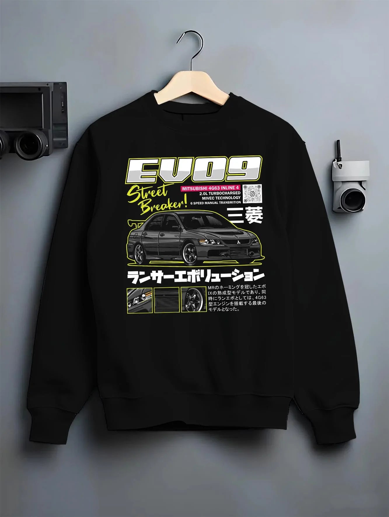 Black crewneck sweatshirt on a hanger against a grey wall, featuring street retro racing performance motorsport automotive graphic.
