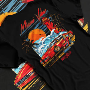 Black T-shirt laid flat with natural fabric folds, featuring street retro racing performance motorsport automotive miamv1.