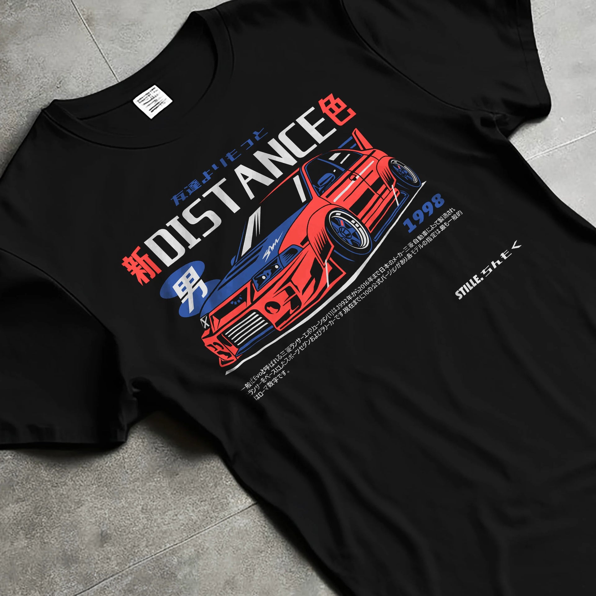 Black T-shirt laid flat with natural fabric folds, featuring Mitsubishi EVO turbo racing drift jdm japanese street graphic.