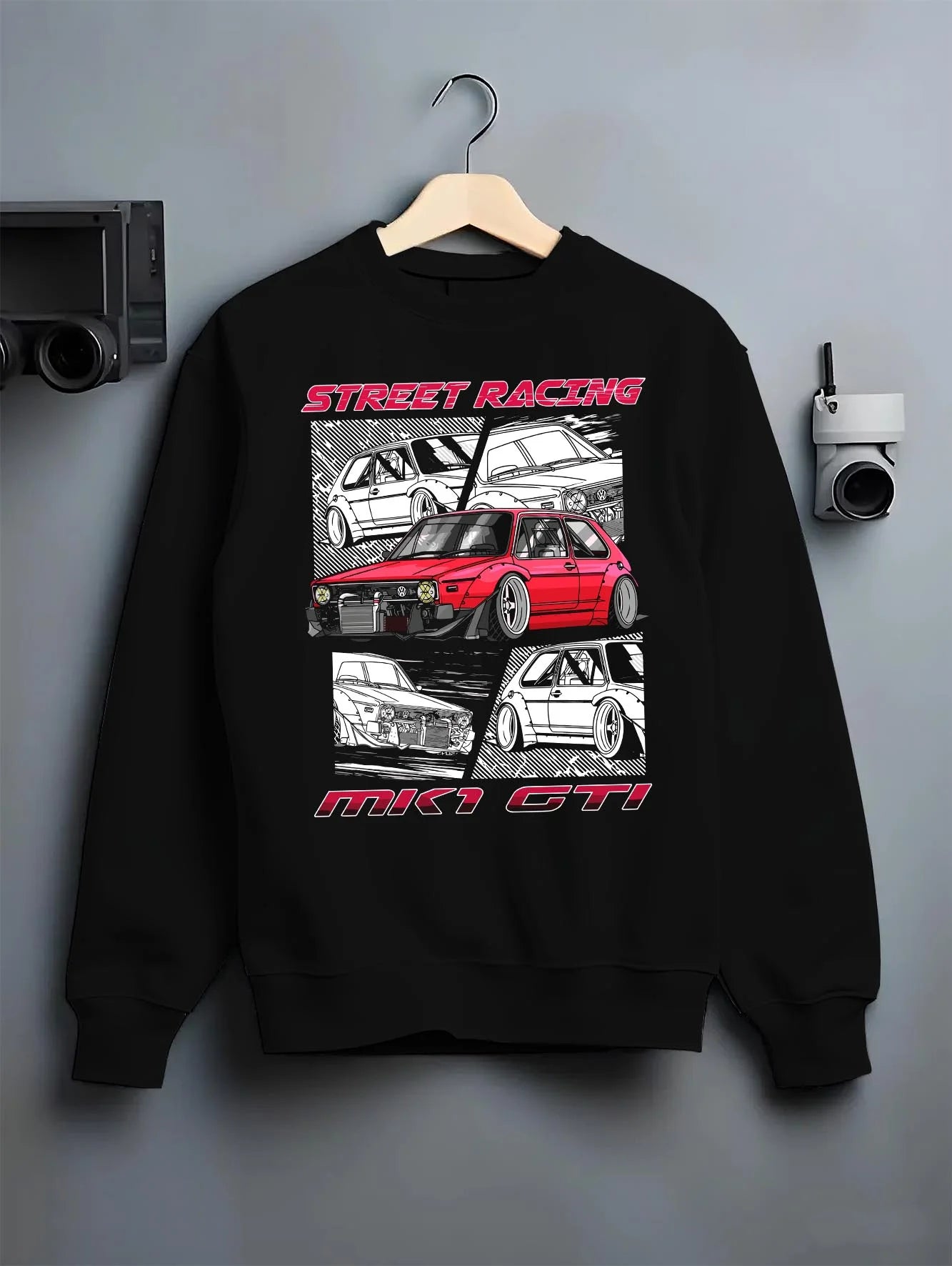 Black crewneck sweatshirt on a hanger against a grey wall, featuring Volkswagen Gti racing tuning street retro enthusiast graphic.