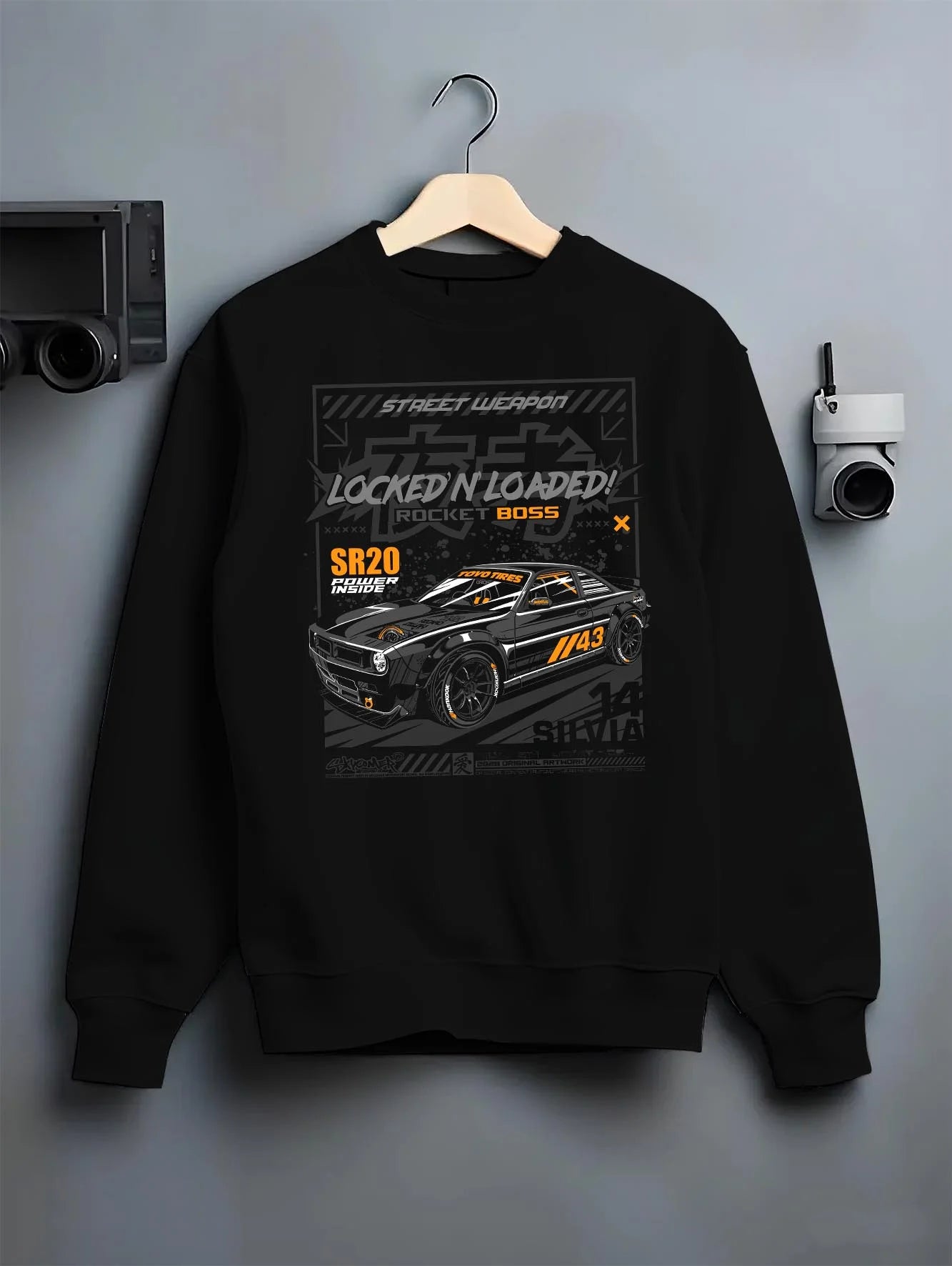 Black crewneck sweatshirt on a hanger against a grey wall, featuring rs racing motorsport need for speed street retro speed graphic.