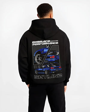 Black hoodie worn by a male model, back view, featuring Nissan Skyline R34 r34 skyline turbo jdm legend racing graphic.