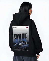 Black hoodie worn by a female model, back view, featuring Nissan Skyline R34 gt r r34 skyline rb26 jdm legend graphic.