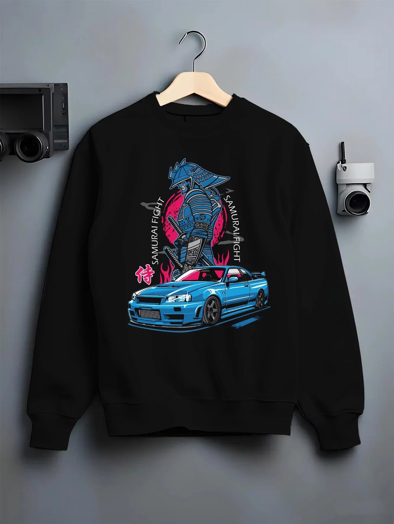 Black crewneck sweatshirt on a hanger against a grey wall, featuring Nissan Skyline R34 gt r r34 skyline drift jdm japanese graphic.