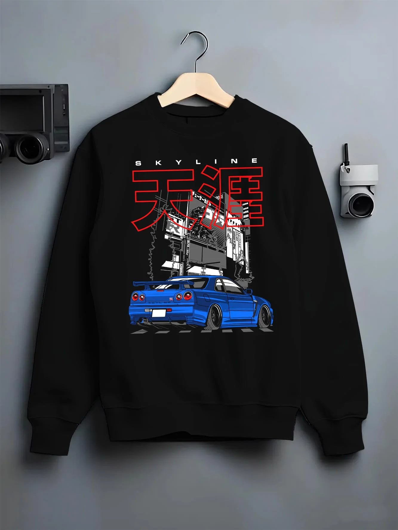 Black crewneck sweatshirt on a hanger against a grey wall, featuring Nissan GT-R gt r turbo turbocharged racing drift jdm graphic.