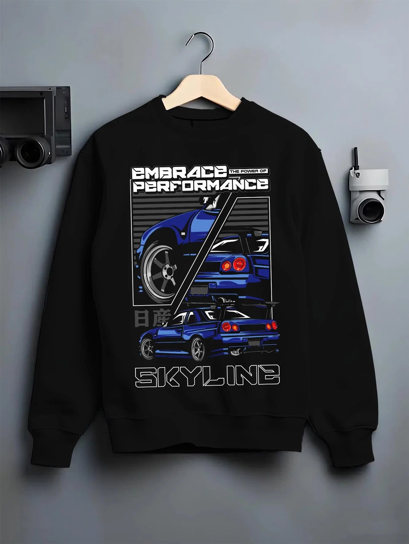 Black crewneck sweatshirt on a hanger against a grey wall, featuring Nissan SKYLINE r32 turbo turbocharged racing drift jdm graphic.