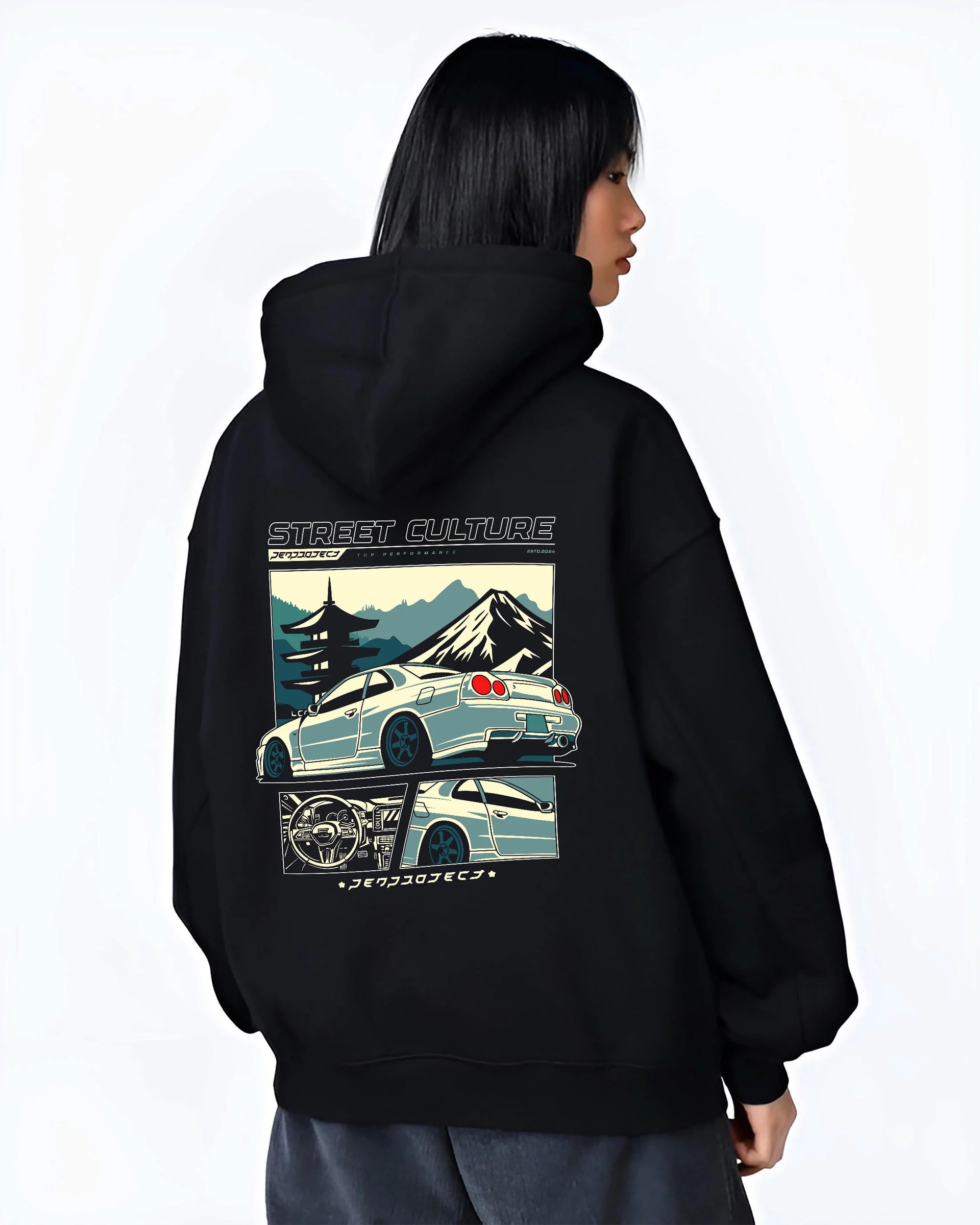 Black hoodie worn by a female model, back view, featuring Nissan Skyline drift jdm japanese tuner street retro graphic.