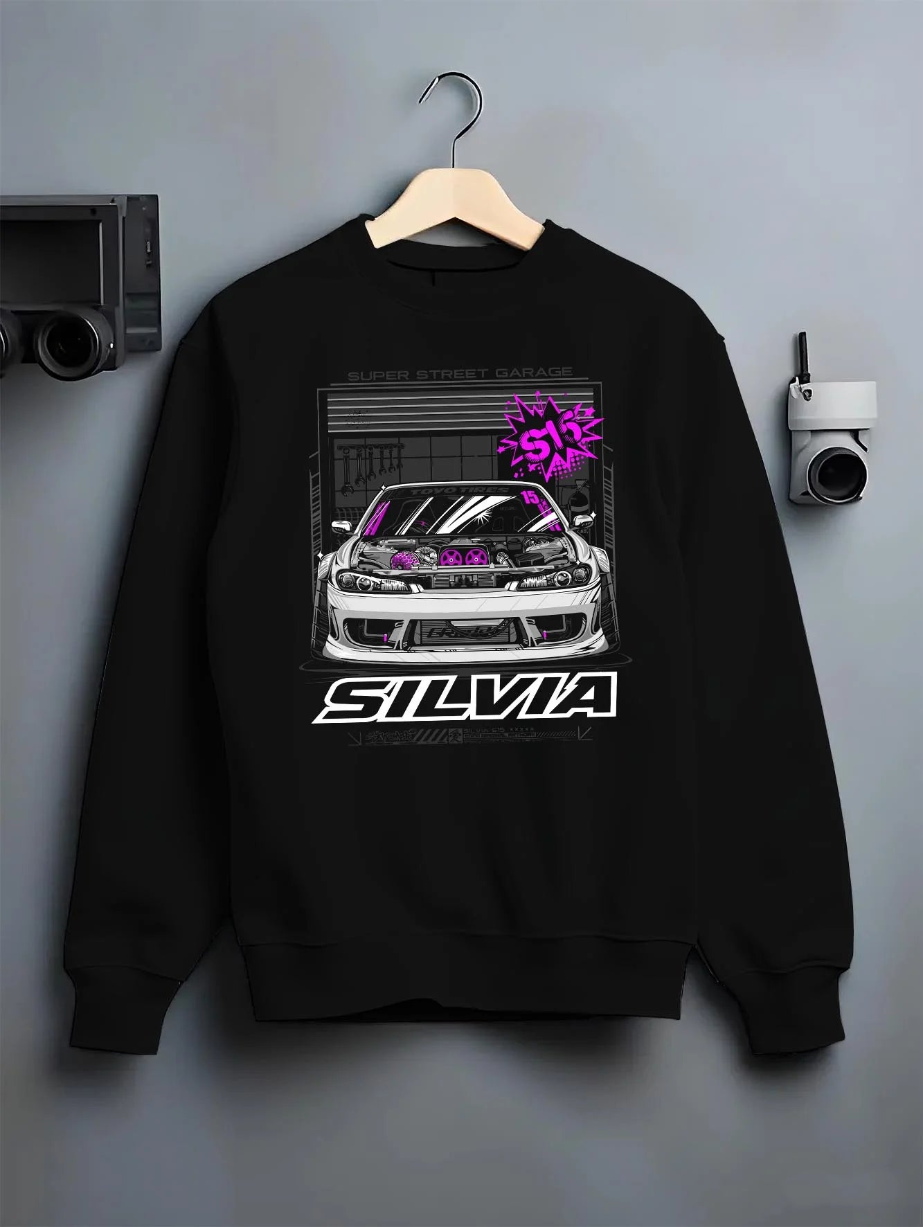 Black crewneck sweatshirt on a hanger against a grey wall, featuring Nissan Silvia S15 silvia turbo drift jdm tuner street graphic.
