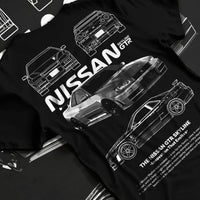 Black T-shirt laid flat with natural fabric folds, featuring Nissan Skyline R34 gtr r34 skyline drift jdm japanese tuner graphic.