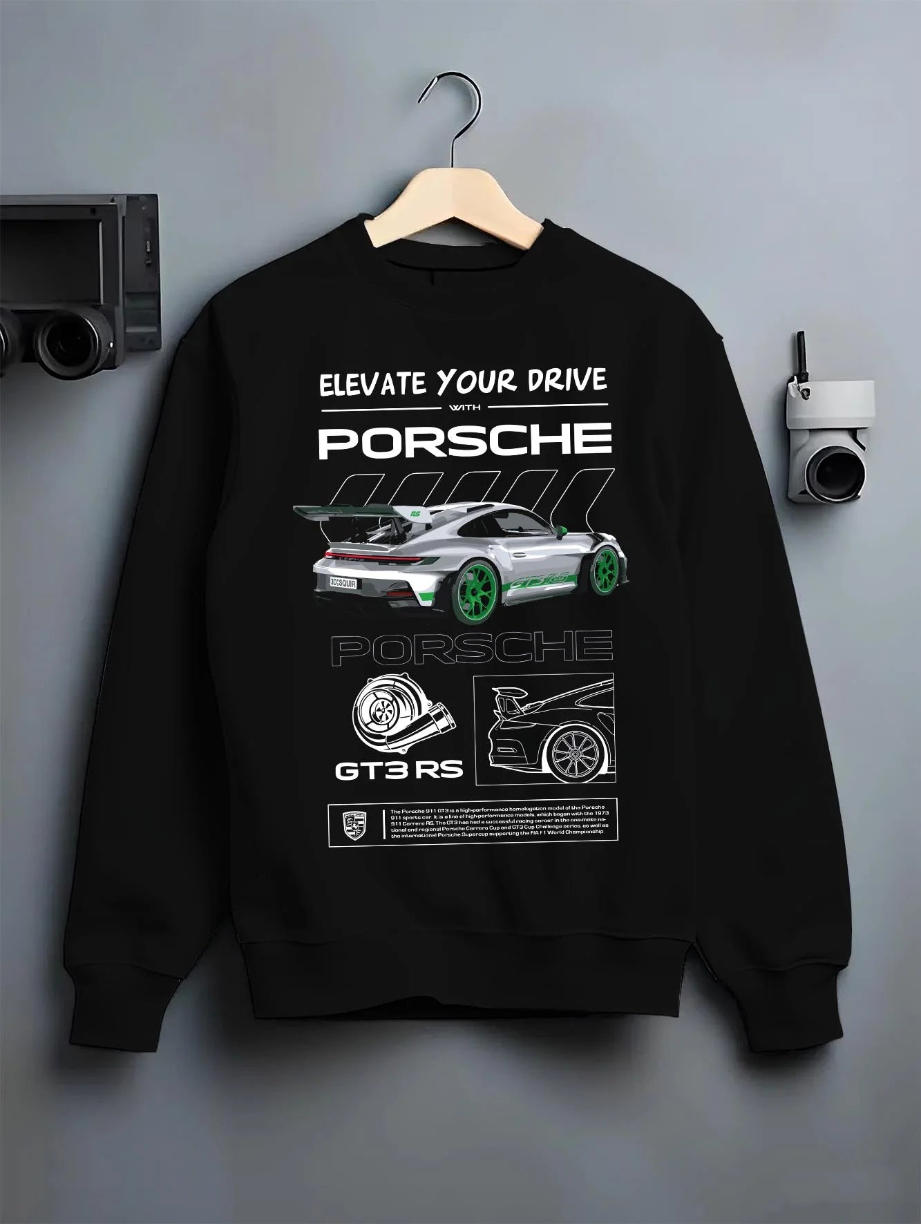 Black crewneck sweatshirt on a hanger against a grey wall, featuring Porsche Boxster rs racing german tuner street classic graphic.