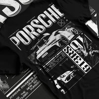 Black T-shirt laid flat with natural fabric folds, featuring Porsche Cayman rs turbo turbocharged racing german tuner graphic.