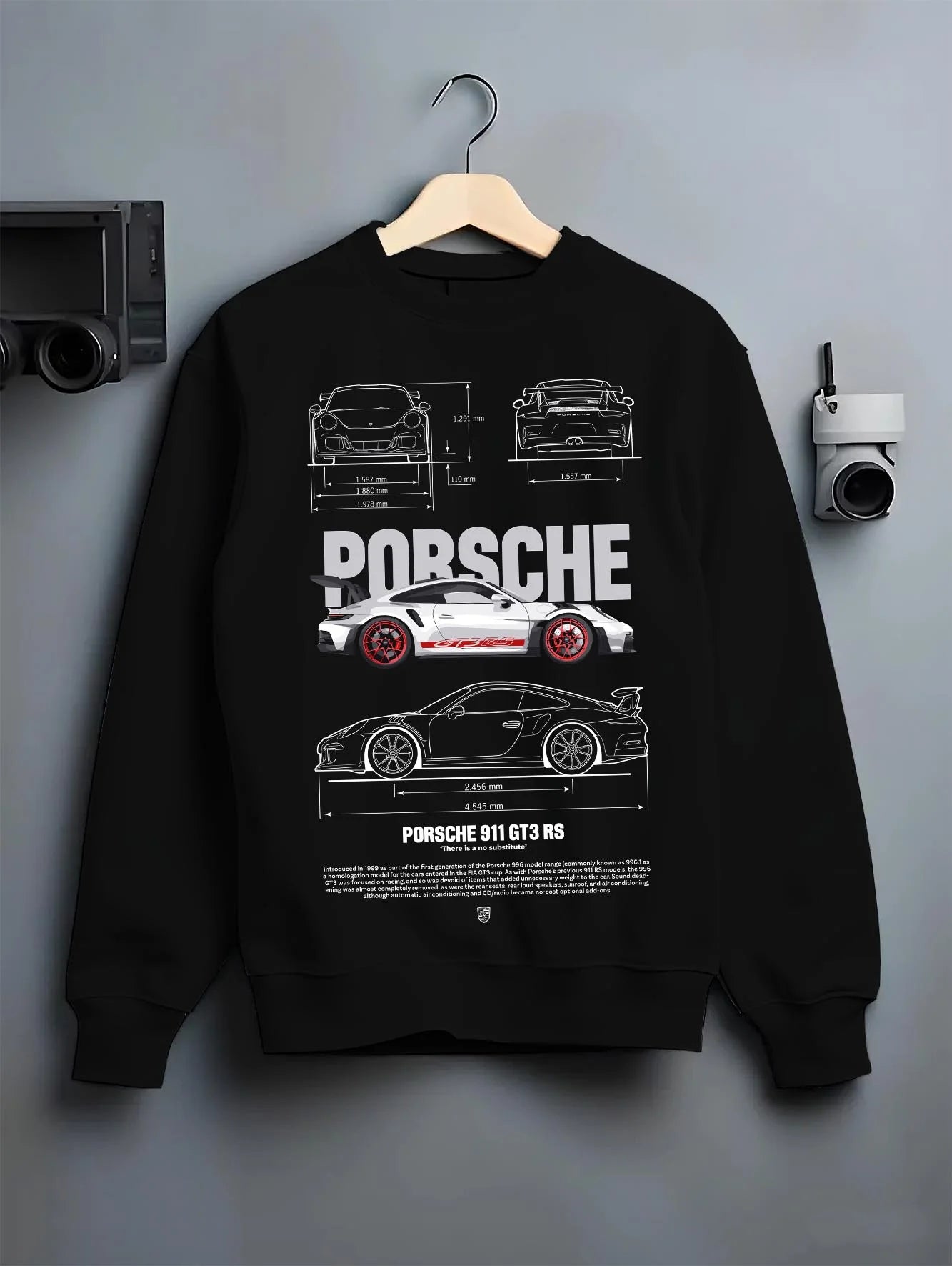 Black crewneck sweatshirt on a hanger against a grey wall, featuring Porsche Panamera rs turbo turbocharged racing german graphic.