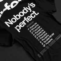 Black T-shirt laid flat with natural fabric folds, featuring Porsche rs racing le mans motorsport street performance graphic.