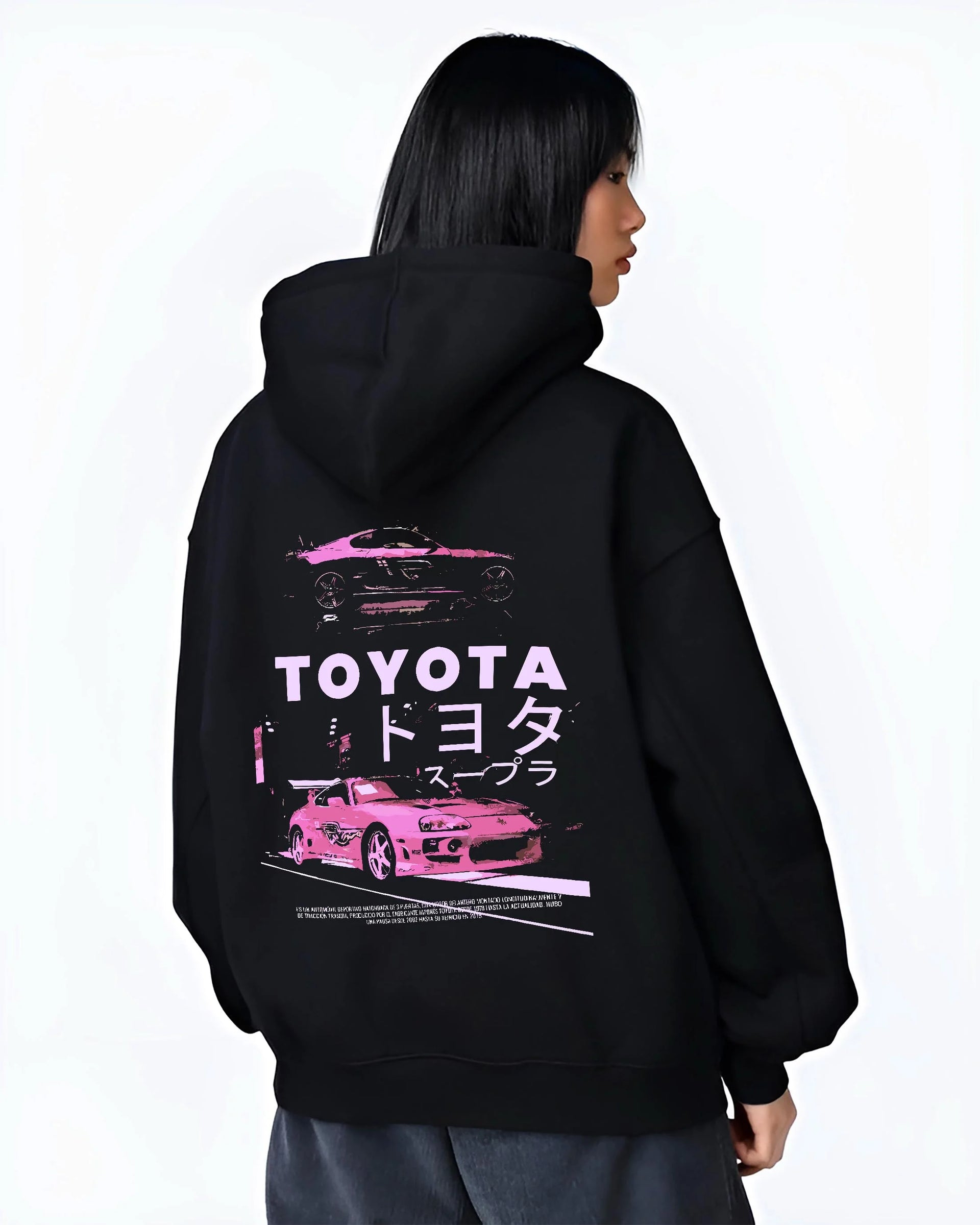 Black hoodie worn by a female model, back view, featuring Toyota Supra racing drift jdm japanese tuner street retro graphic.
