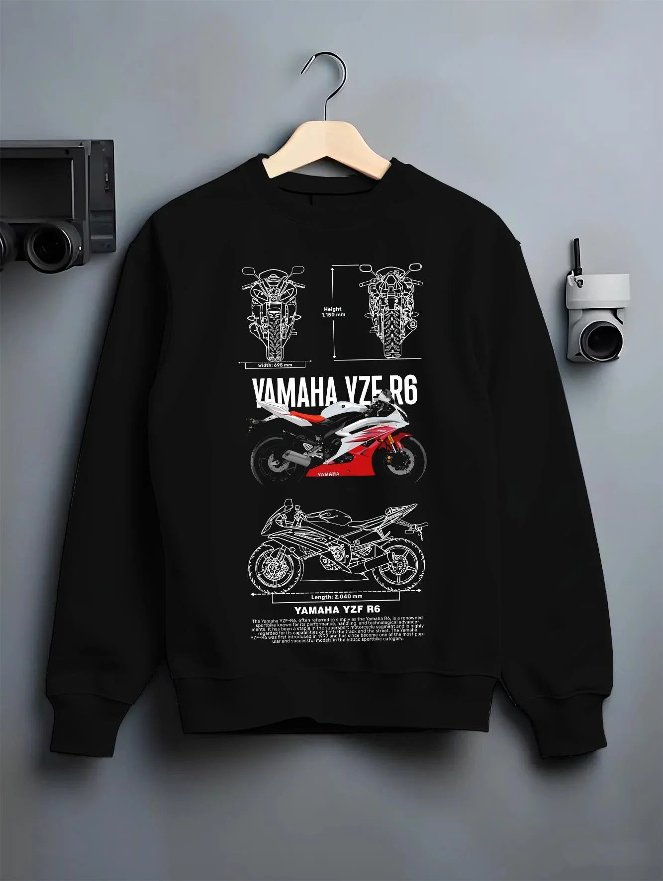 Black crewneck sweatshirt on a hanger against a grey wall, featuring Yamaha R6 racing street enthusiast performance graphic.