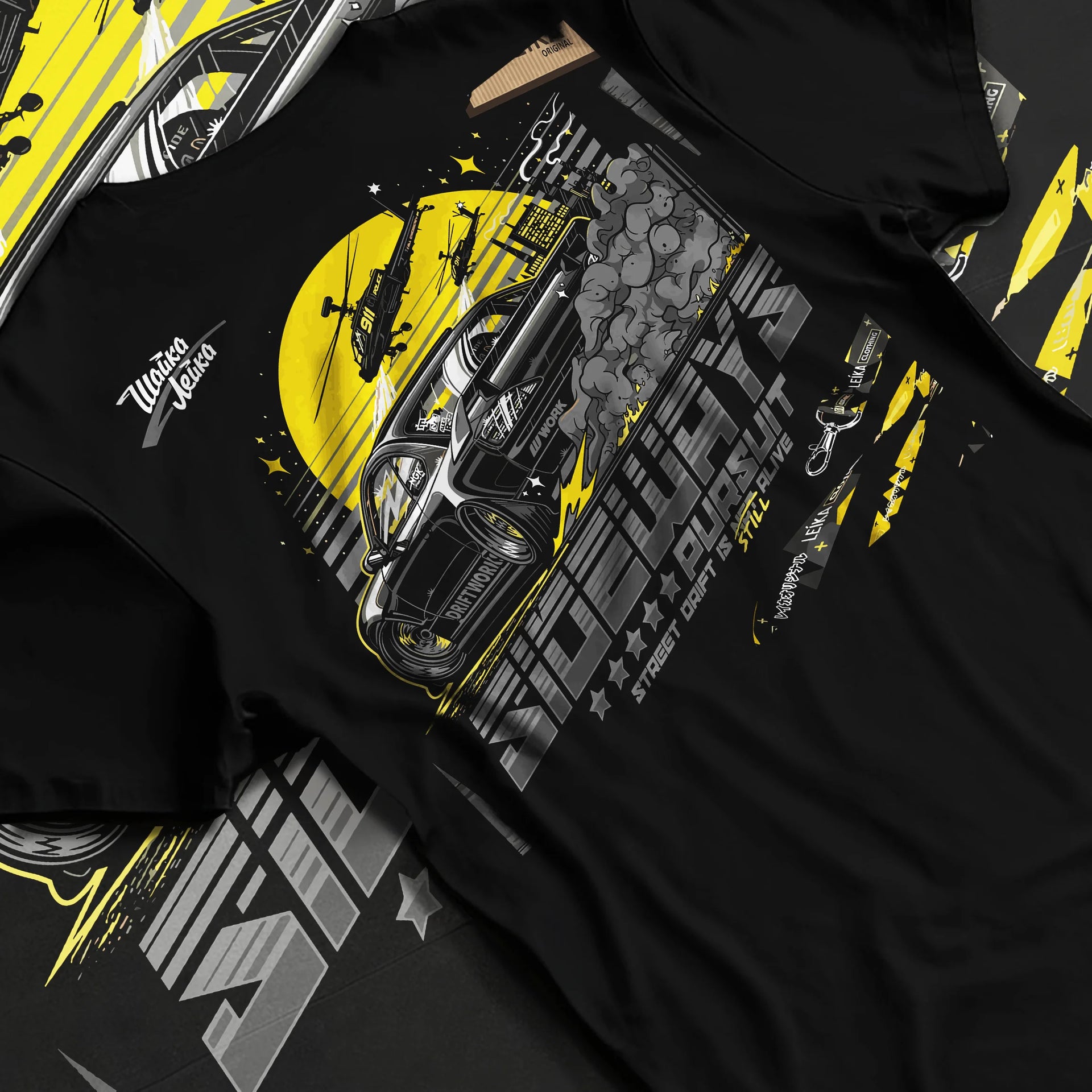 Black T-shirt laid flat with natural fabric folds, featuring rs turbo turbocharged racing drift jdm japanese tuner tokyo graphic.