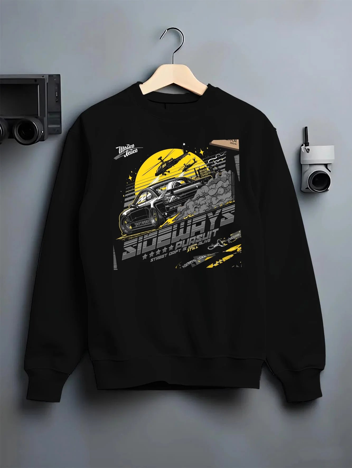 Black crewneck sweatshirt on a hanger against a grey wall, featuring rs turbo turbocharged racing drift jdm japanese tuner graphic.