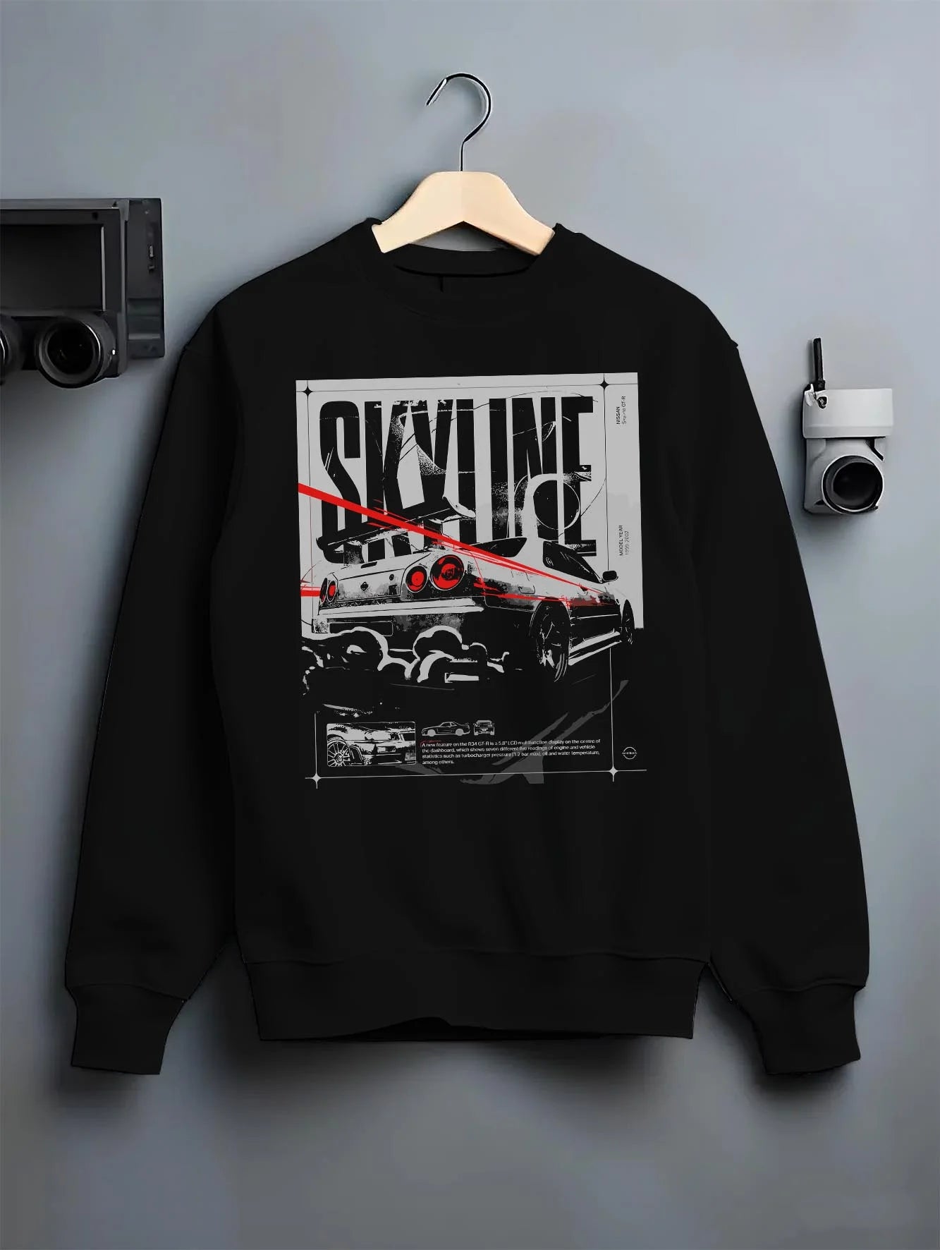 Black crewneck sweatshirt on a hanger against a grey wall, featuring Nissan Skyline R34 r34 skyline turbo turbocharged graphic.
