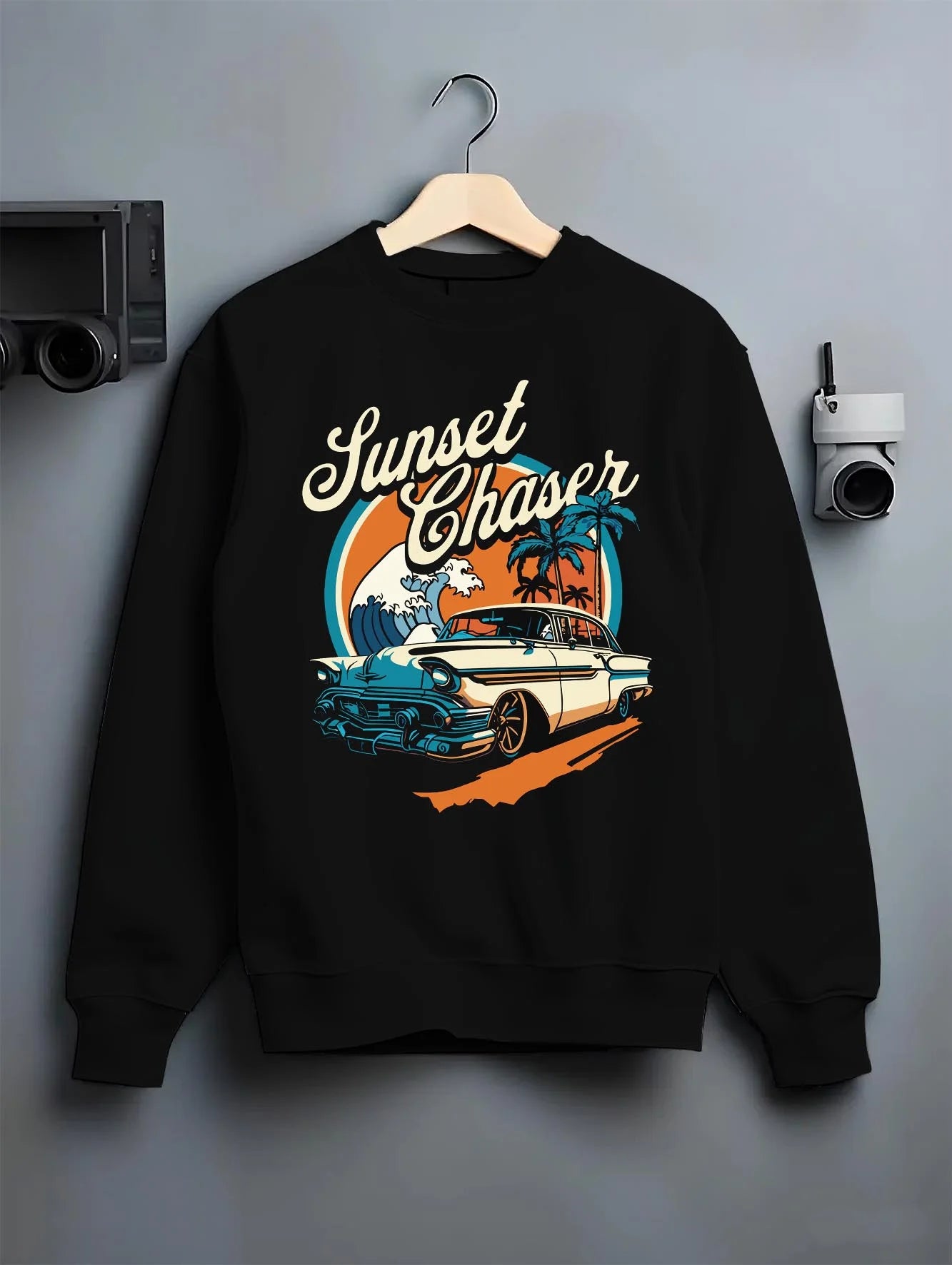 Black crewneck sweatshirt on a hanger against a grey wall, featuring Chevrolet classic racing street performance motorsport graphic.