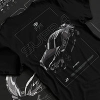 Black T-shirt laid flat with natural fabric folds, featuring Toyota Supra turbo turbocharged racing drift jdm tuner graphic.