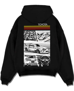 Black pullover hoodie laid flat on a white background, featuring Toyota Supra rs racing jdm tuner street vintage enthusiast graphic.