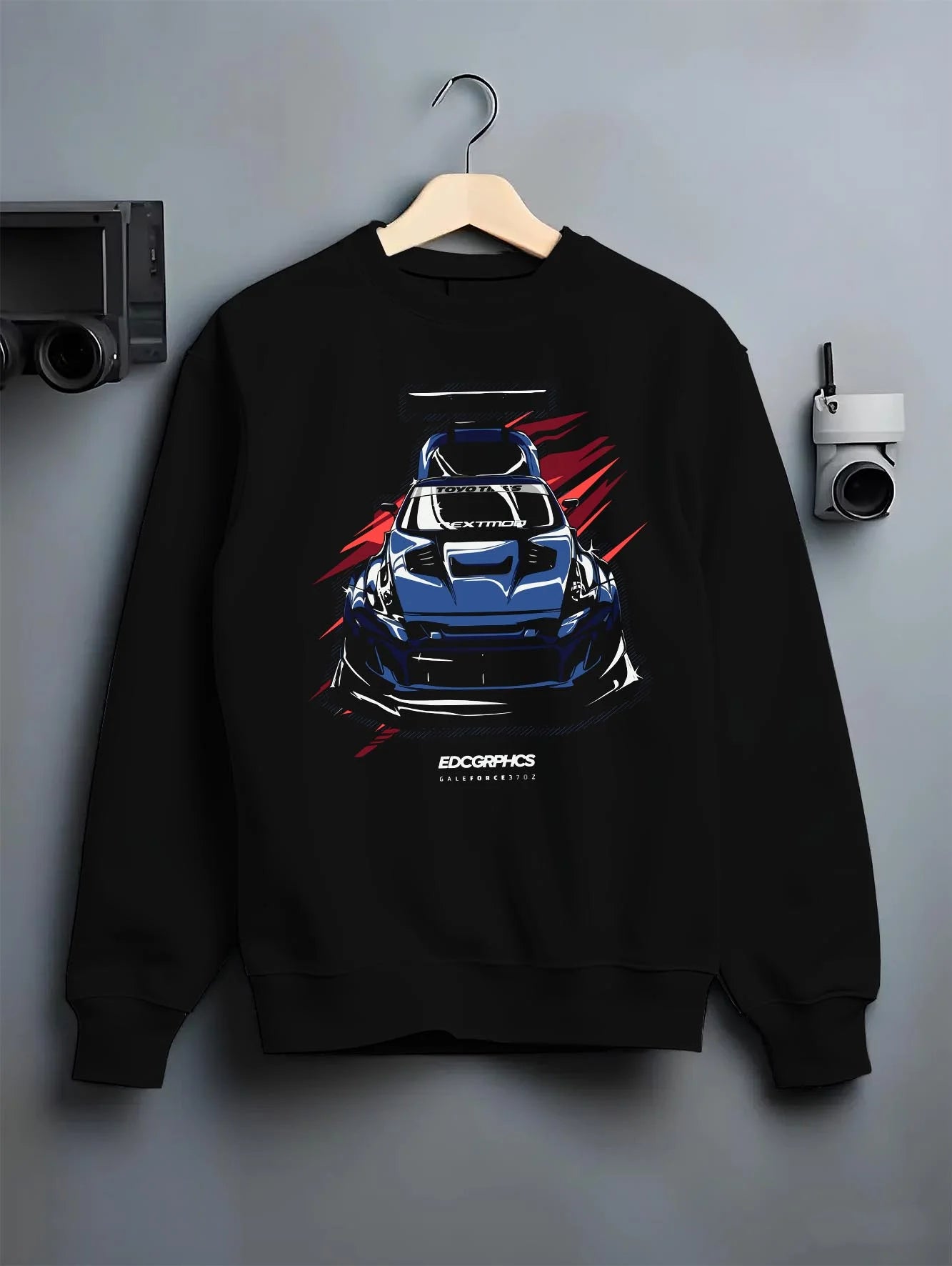 Black crewneck sweatshirt on a hanger against a grey wall, featuring Nissan 370Z turbo racing drift jdm tuner widebody graphic.
